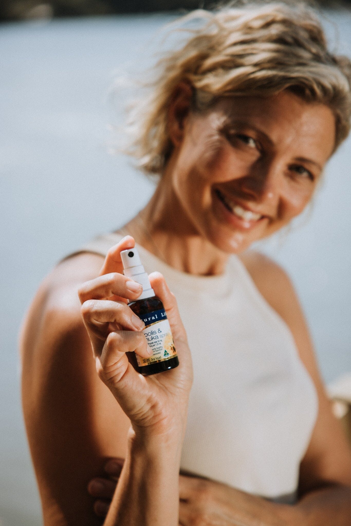 Lady holding Natural Life's Propolis & Manuka Honey Spray