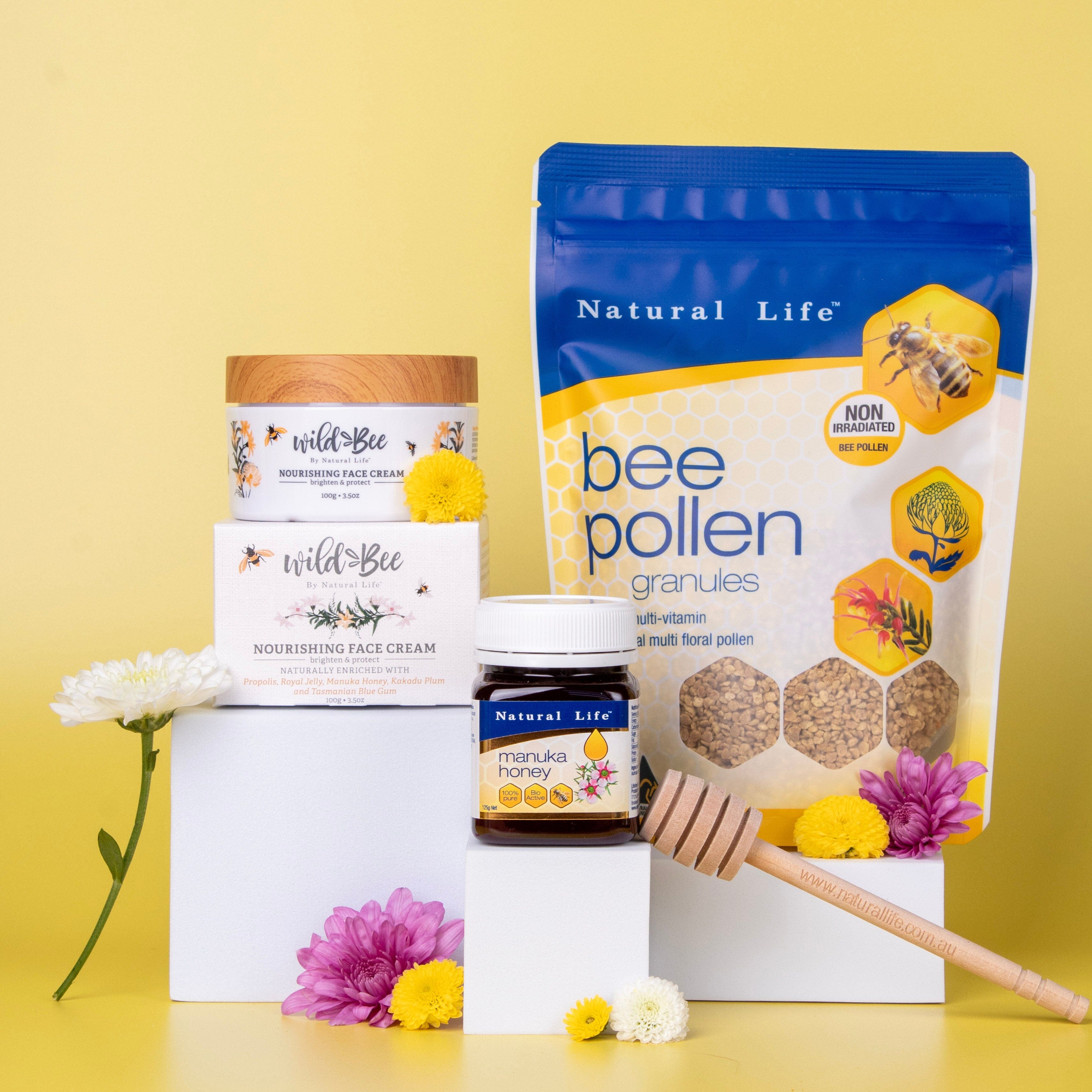 Natural Life bee pollen granules packaging with honey jar and face cream on a yellow background